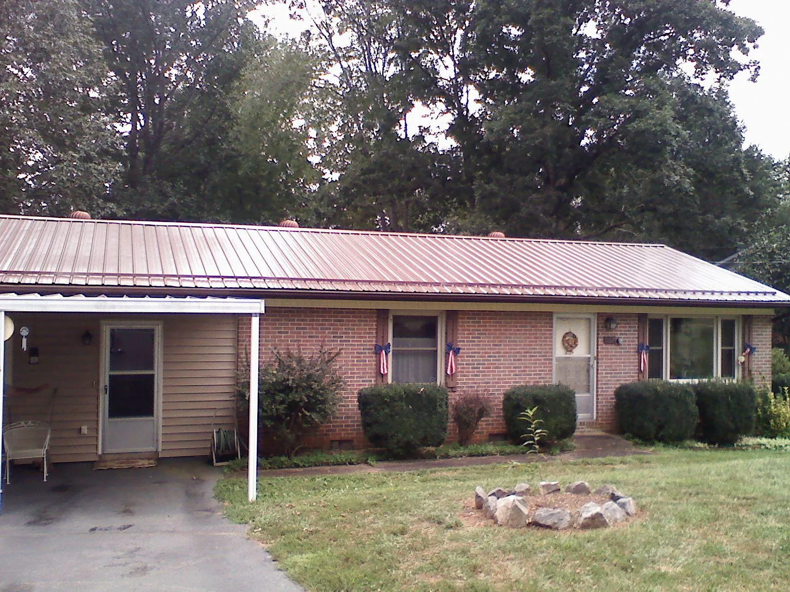 Bronze metal roof and carport on a brick ranch home — Roof Repair work by our crew in Chiloquin